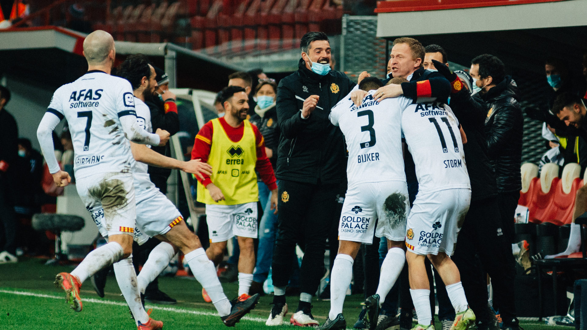 Spelers van KV Mechelen die samen met de technische staf vieren na het winnende doelpunt van Nikola Storm.